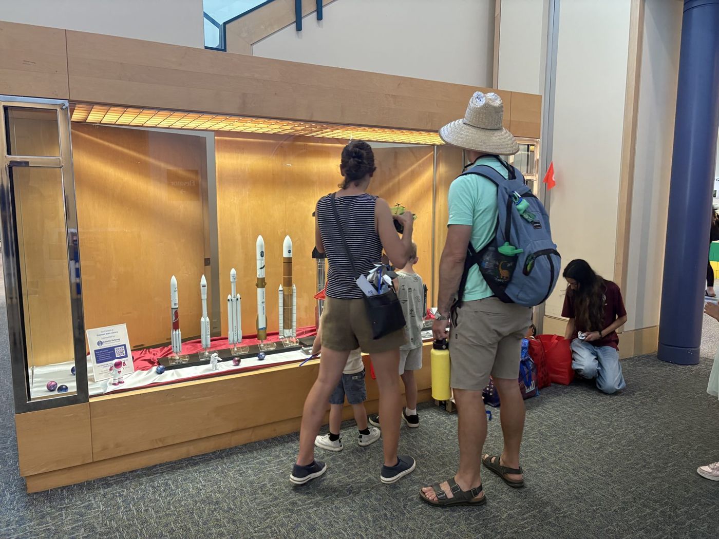 A family gathered around the rocket display case