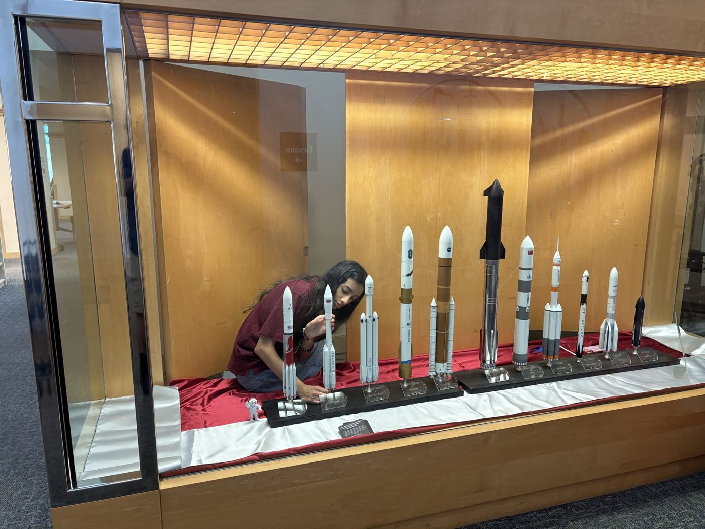 Saanvi Phaneendra installing rocket models in the display case at Fremont Main Library