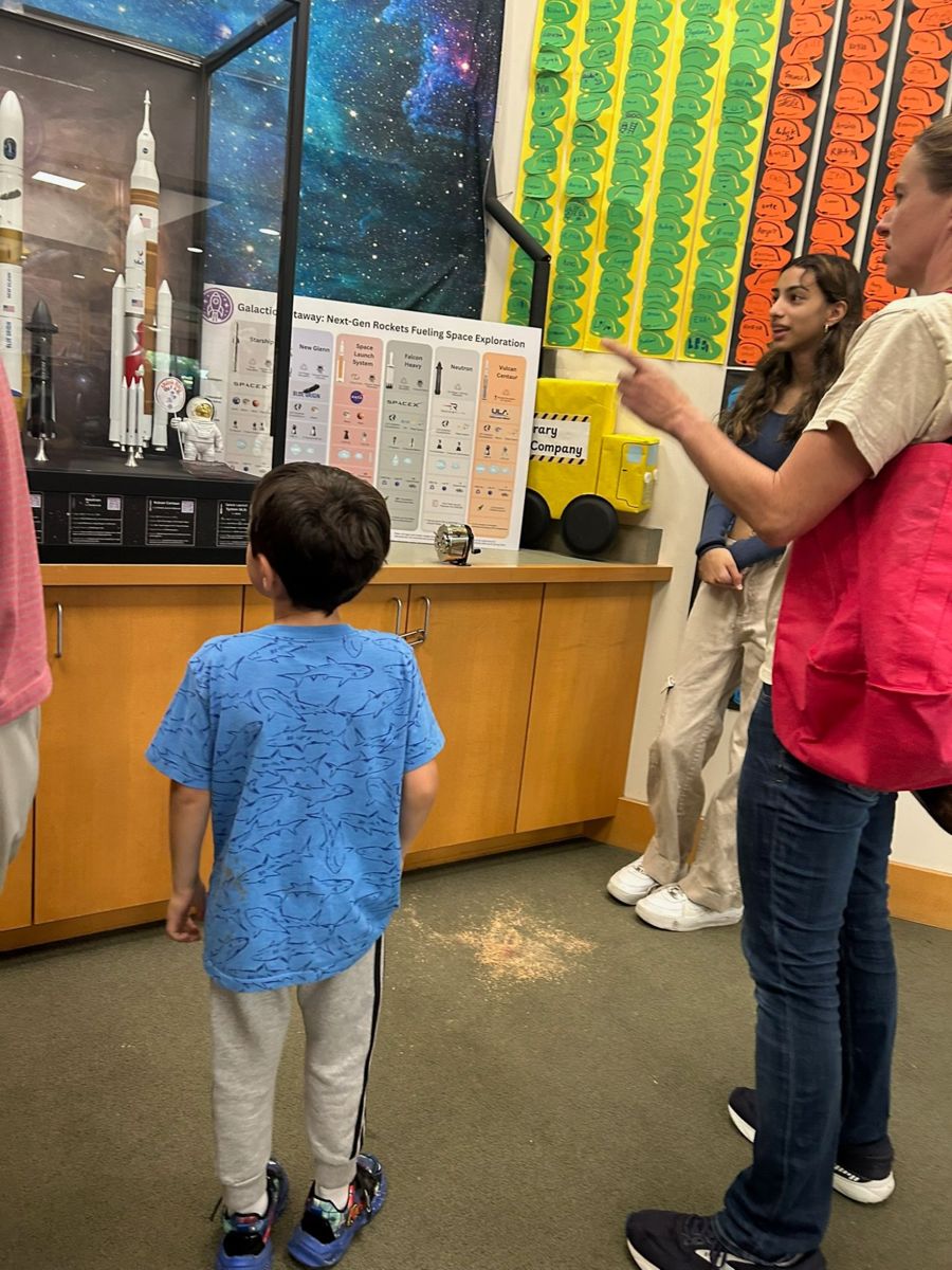 A young visitor looking at Galactic Getaway rocket models up close