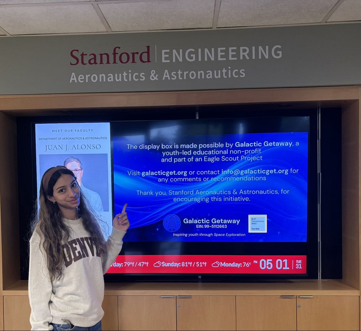 Saanvi Phaneendra beside the Galactic Getaway exhibit screen at Stanford Aeronautics and Astronautics