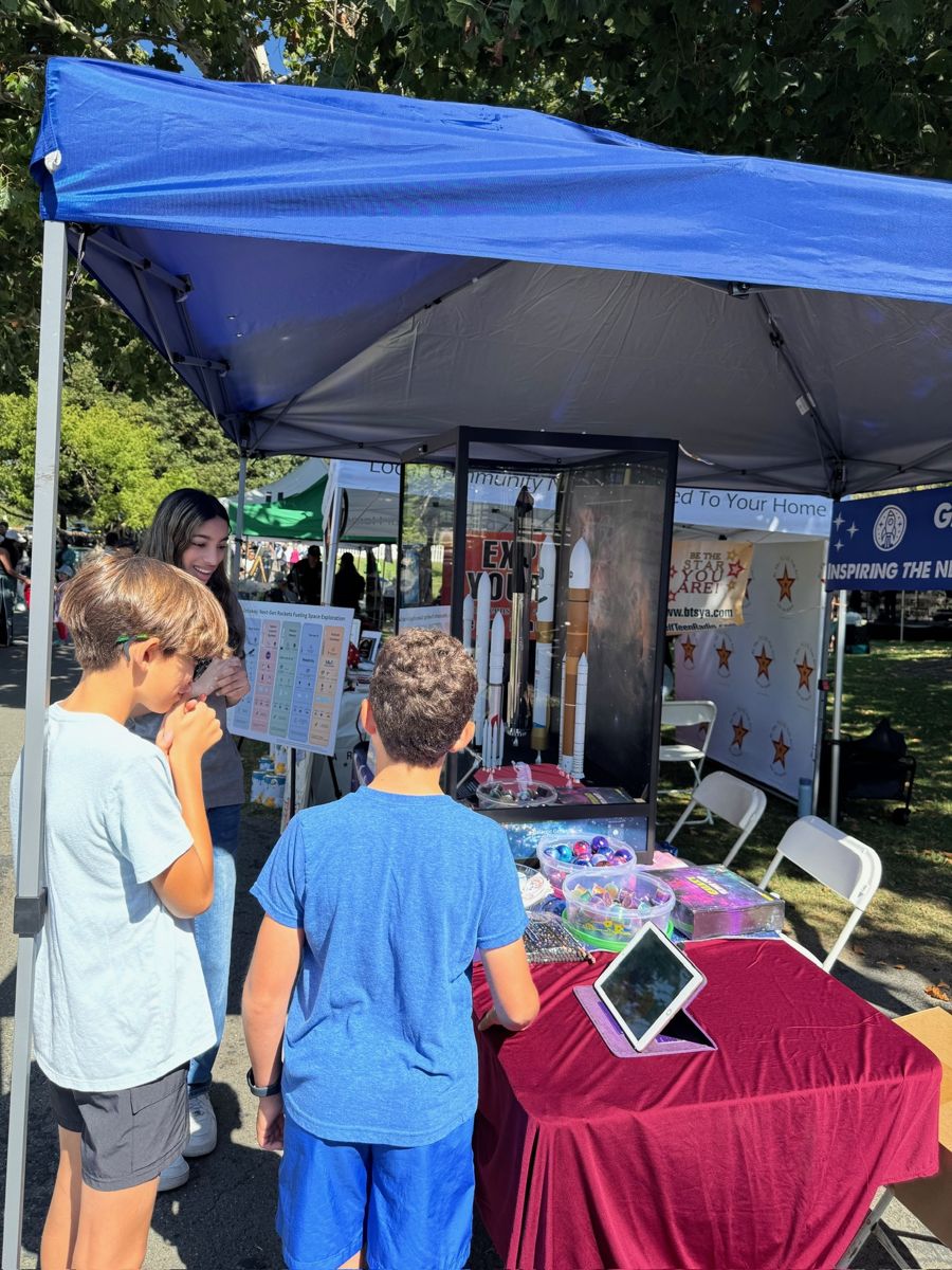 Kids exploring the Galactic Getaway rocket booth at a community festival